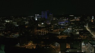 DX0002_210_041 - 5.7K aerial stock footage of flying away from the Genesee River and skyline at night, Downtown Rochester, New York