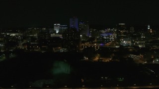 DX0002_210_049 - 5.7K aerial stock footage of a view of the city's skyline, the Genesee River, and High Falls at night, Downtown Rochester, New York