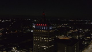 DX0002_210_054 - 5.7K aerial stock footage of orbiting the top of Kodak Tower at night, Rochester, New York