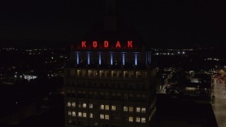 DX0002_210_056 - 5.7K aerial stock footage of flying away from the top of Kodak Tower at night, Rochester, New York