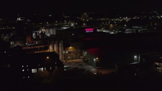 DX0002_210_061 - 5.7K aerial stock footage of approaching a brewery at night, Rochester, New York