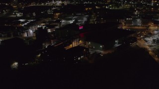 DX0002_210_062 - 5.7K aerial stock footage of flying away from a brewery at night, Rochester, New York