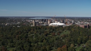 DX0002_211_001 - 5.7K aerial stock footage of flying away from Carrier Dome, Downtown Syracuse in the background, New York