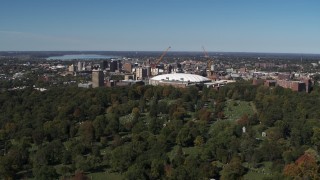 DX0002_211_002 - 5.7K aerial stock footage of flying over cemetery to approach and flyby Carrier Dome and Downtown Syracuse, New York