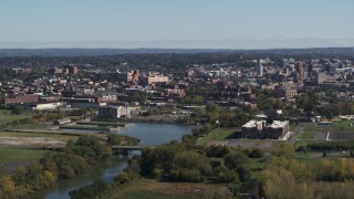 DX0002_211_037 - 5.7K aerial stock footage of an apartment complex beside Onondaga Creek, Downtown Syracuse in background, New York