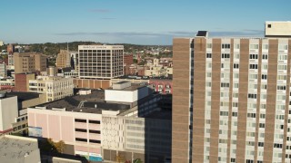 DX0002_213_022 - 5.7K aerial stock footage of flying by an apartment building to reveal office buildings, Downtown Syracuse, New York