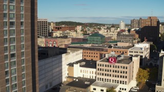 DX0002_213_024 - 5.7K aerial stock footage of passing by an apartment building to reveal office buildings, Downtown Syracuse, New York