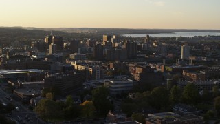 DX0002_214_016 - 5.7K aerial stock footage of flying by downtown seen from Syracuse University at sunset, New York