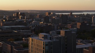 DX0002_214_025 - 5.7K aerial stock footage of Downtown Syracuse at sunset, seen while descending next to dormitory building, New York