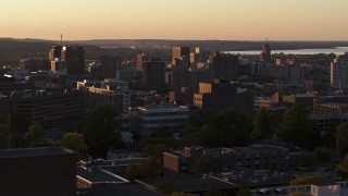 DX0002_214_026 - 5.7K aerial stock footage of Downtown Syracuse at sunset, seen while flying by dormitory buildings, New York