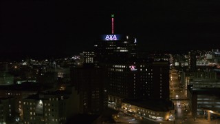 DX0002_215_035 - 5.7K aerial stock footage of flying away from office tower and hotel at night, Downtown Syracuse, New York