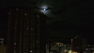 DX0002_215_043 - 5.7K aerial stock footage of the moon while flying by apartment building, Downtown Syracuse, New York