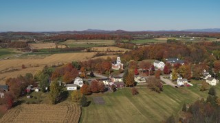 DX0002_217_002 - 5.7K aerial stock footage orbit a church in the small town of Orwell, Vermont, farm fields in background