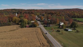 DX0002_217_012 - 5.7K stock footage aerial video flyby a country road beside a small town in autumn, Orwell, Vermont