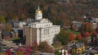 DX0002_218_039 - 5.7K aerial stock footage descend by a government office building, capitol dome behind it, Montpelier, Vermont