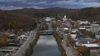 DX0002_220_002 - 5.7K aerial stock footage reverse view of a bridge spanning the Winooski River at sunset, Montpelier, Vermont