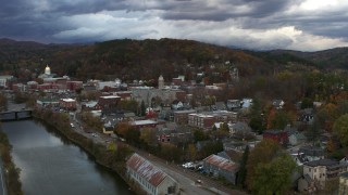 DX0002_220_011 - 5.7K aerial stock footage of a wide orbit of city hall and brick buildings at sunset, approach from river, Montpelier, Vermont