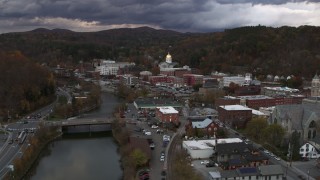 DX0002_220_018 - 5.7K aerial stock footage of flying over a bridge on the river with a view of the state capitol at sunset, Montpelier, Vermont