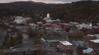 DX0002_220_025 - 5.7K aerial stock footage ascend and fly away from capitol dome at sunset seen from the river, Montpelier, Vermont