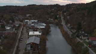 DX0002_220_035 - 5.7K aerial stock footage of flying by and away from the river and Berlin Street at sunset, Montpelier, Vermont