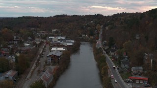 DX0002_220_036 - 5.7K aerial stock footage of a stationary view of the river and Berlin Street at sunset, Montpelier, Vermont