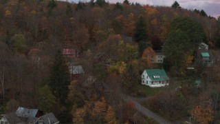 DX0002_220_040 - 5.7K aerial stock footage of circling homes on a hill at sunset, Montpelier, Vermont