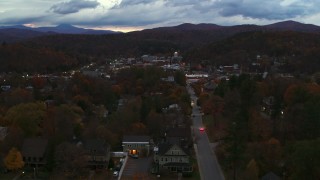 DX0002_220_052 - 5.7K aerial stock footage of the downtown area of the city seen from homes and fall trees at twilight, Montpelier, Vermont