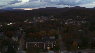 DX0002_220_054 - 5.7K aerial stock footage of flying by the downtown area of the city seen from homes and fall trees at twilight, Montpelier, Vermont