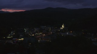 DX0002_220_063 - 5.7K aerial stock footage of passing by city buildings around the capitol dome lit up at twilight, Montpelier, Vermont