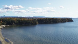 DX0002_223_007 - 5.7K aerial stock footage of a reverse view of forest on Lone Rock Point by Lake Champlain, and descend, Burlington, Vermont