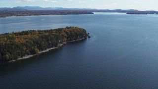 DX0002_223_025 - 5.7K aerial stock footage of a reverse view of forest on the tip of Lone Rock Point by Lake Champlain, Burlington, Vermont
