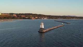 DX0002_225_008 - 5.7K aerial stock footage fly low over Lake Champlain lighthouse toward downtown at sunset, Burlington, Vermont