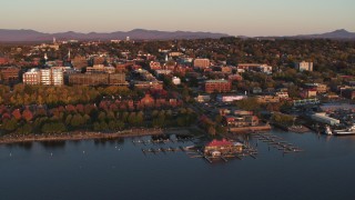 DX0002_225_014 - 5.7K stock footage aerial video of buildings and park in downtown behind a marina at sunset, Burlington, Vermont
