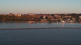 DX0002_225_018 - 5.7K stock footage aerial video fly over Lake Champlain breakwater at sunset to approach downtown, Burlington, Vermont