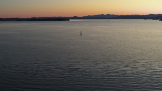 DX0002_225_033 - 5.7K stock footage aerial video approach sailboat on Lake Champlain at twilight, Burlington, Vermont