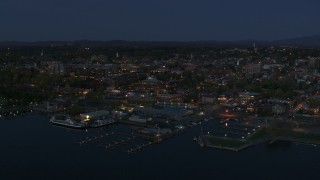 DX0002_226_019 - 5.7K aerial stock footage a stationary view of city's downtown area and a marina at night, Burlington, Vermont