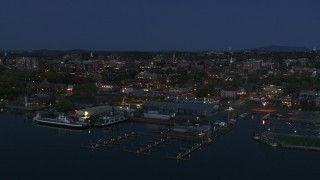 DX0002_226_020 - 5.7K aerial stock footage descend past the city's downtown area and a marina at night, Burlington, Vermont