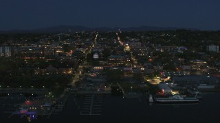 DX0002_226_028 - 5.7K aerial stock footage focus on the city's downtown area lit up for the night, fly away from marinas, Burlington, Vermont