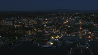 DX0002_226_029 - 5.7K aerial stock footage focus on the city's downtown area lit up for the night, seen from marinas, Burlington, Vermont