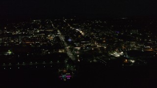 DX0002_226_042 - 5.7K stock footage aerial video of flying away from and orbiting office buildings and streets in downtown lit up for nighttime, Burlington, Vermont