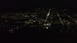 DX0002_226_043 - 5.7K aerial stock footage of orbiting buildings and streets in downtown lit up for nighttime, Burlington, Vermont