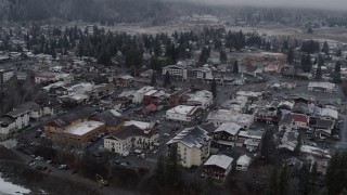 DX0002_227_006 - 5.7K aerial stock footage of orbiting rooftops with light snow in the small town of Leavenworth, Washington