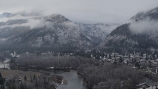 DX0002_227_019 - 5.7K aerial stock footage of flying away from Leavenworth and snowy mountains, Washington