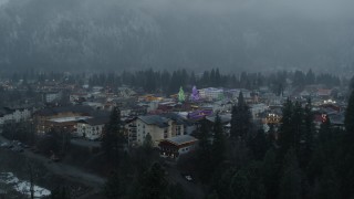 DX0002_227_033 - 5.7K aerial stock footage fly over trees to reveal town with tall Christmas trees, Leavenworth, Washington