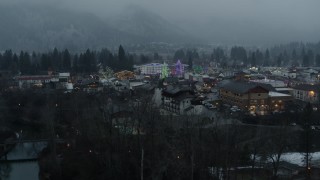 DX0002_227_038 - 5.7K aerial stock footage of orbiting town while focused on tall Christmas trees, Leavenworth, Washington