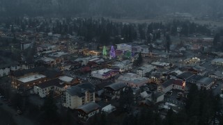 DX0002_227_040 - 5.7K aerial stock footage orbit town while focused on tall Christmas trees, Leavenworth, Washington