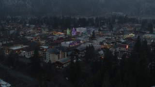 DX0002_227_049 - 5.7K aerial stock footage fly away from a small town decorated with Christmas trees and lights, Leavenworth, Washington