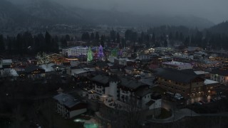 DX0002_227_052 - 5.7K aerial stock footage circling a small town decorated with Christmas trees and lights, Leavenworth, Washington