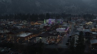 DX0002_227_053 - 5.7K aerial stock footage of a small town decorated with Christmas trees and lights, Leavenworth, Washington