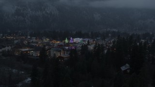 DX0002_227_055 - 5.7K aerial stock footage of a small town with Christmas trees and lights seen during descent, twilight, Leavenworth, Washington